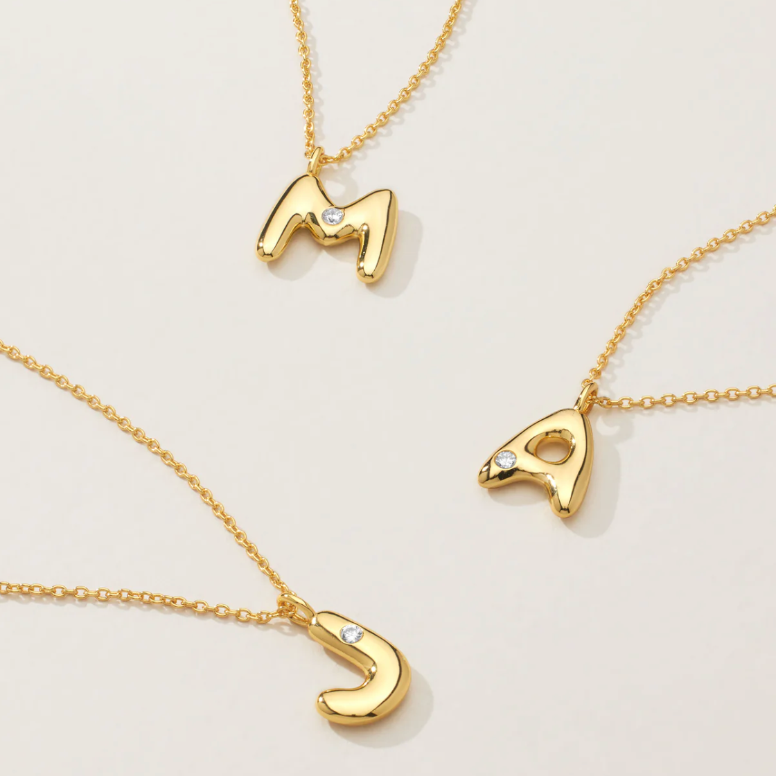 Mini bubble letter initial necklace with bezel, crafted in sterling silver for durability and water-resistance, offering a playful and personalized look for everyday wear.