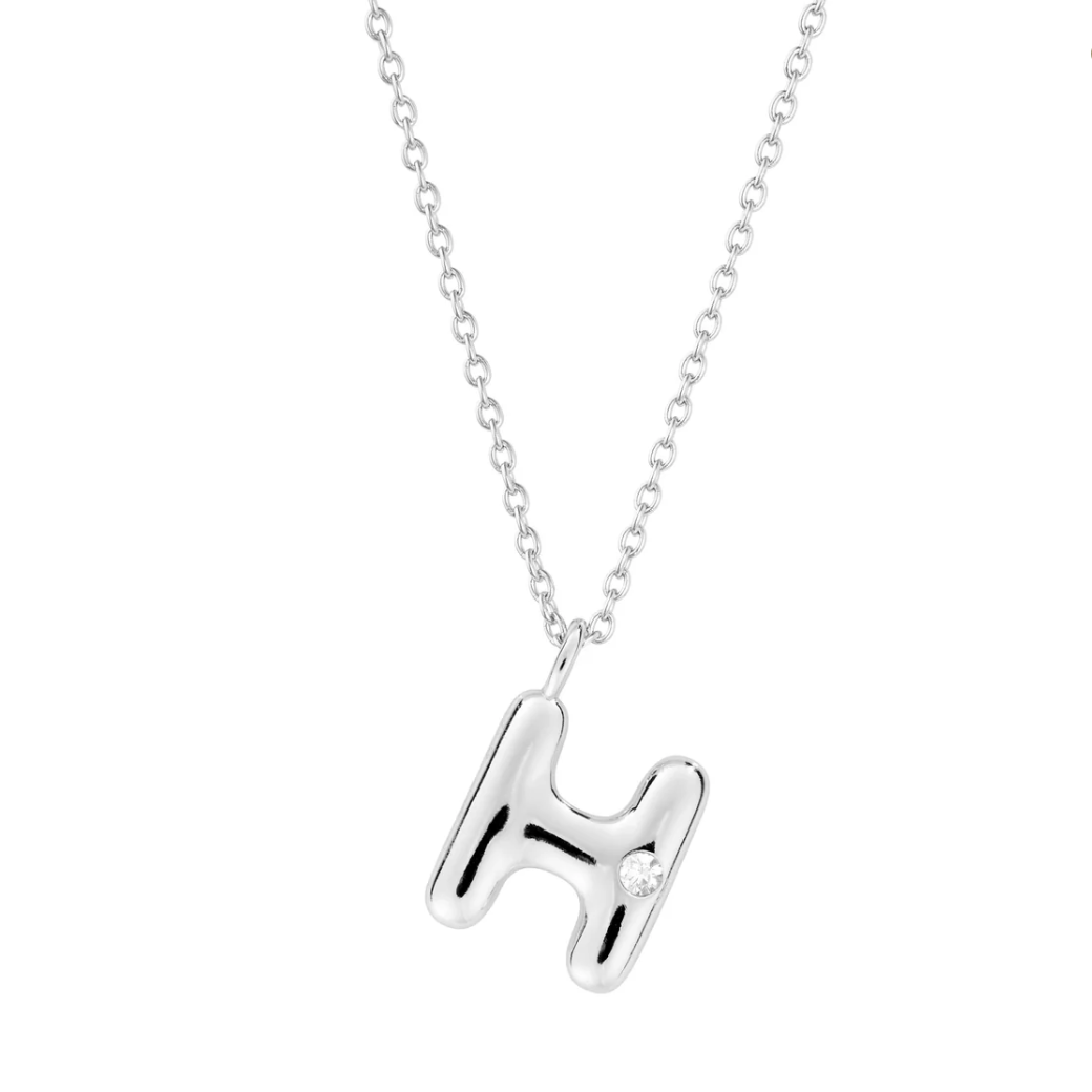 Mini bubble letter initial necklace with bezel, crafted in sterling silver for durability and water-resistance, offering a playful and personalized look for everyday wear.