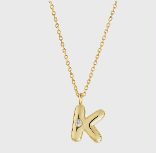 Mini bubble letter initial necklace with bezel, crafted in sterling silver for durability and water-resistance, offering a playful and personalized look for everyday wear.